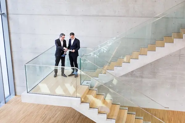 Beispiel Businessfotografie: Zwei Männer im Anzug im Gespräch auf einer Treppe
